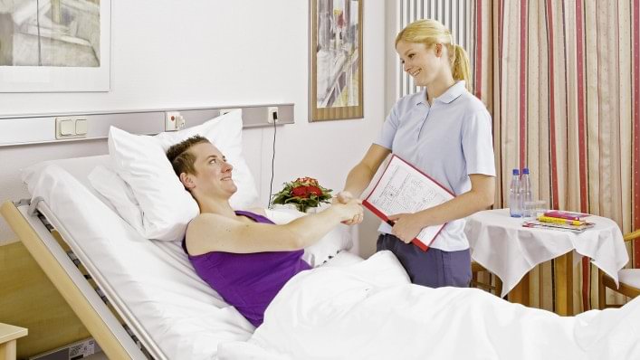 Therapeutin begrüßt Anwenderin Julia im Krankenhaus.