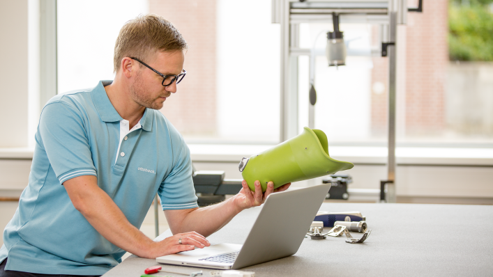 Mann sitzt vor Laptop